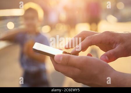 Bild`s die Hände eines Mannes mit einem Smartphone, Nahaufnahme. Junger Mann mit Handy. Stockfoto